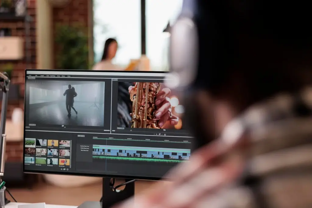 Productor audiovisual mirando a una pantalla de ordenador con edición de audio y vídeo