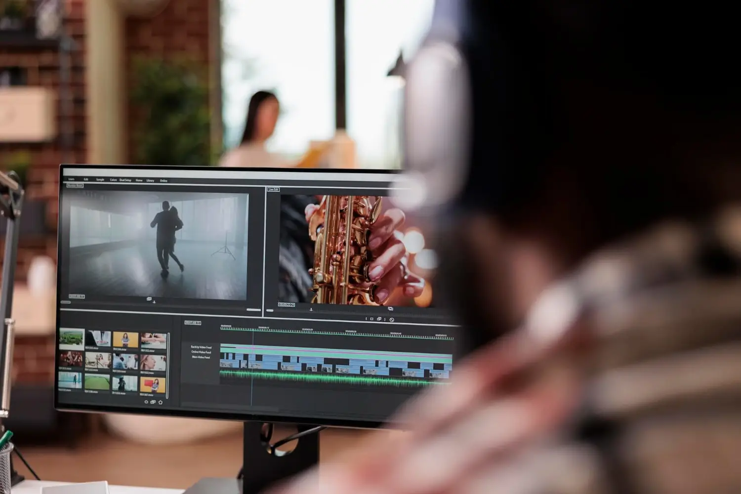 Productor audiovisual mirando a una pantalla de ordenador con edición de audio y vídeo